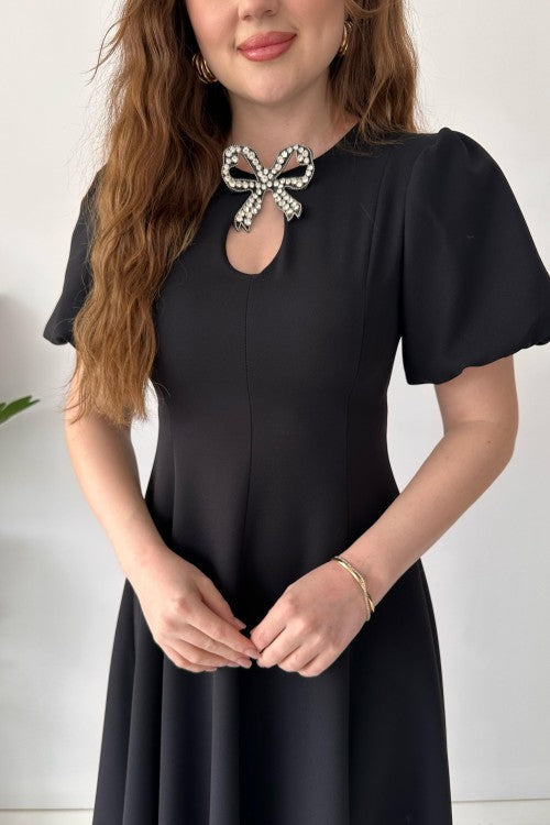 Robe en crêpe noire avec broche et nœud