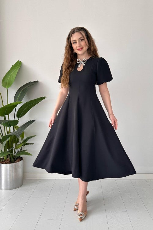 Robe en crêpe noire avec broche et nœud