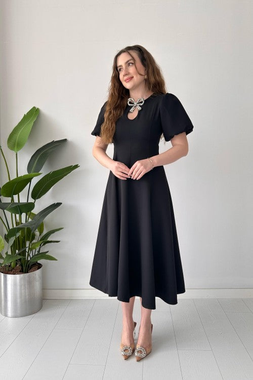 Robe en crêpe noire avec broche et nœud